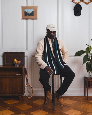 Homme portant une tenue Val Mont Lac assis sur un tabouret en bois vintage