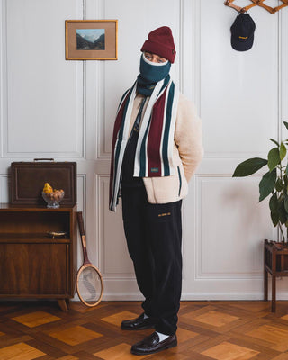 Val Mont Lac model standing in front of a vintage danish teak sideboard, a painting of a mountain landscape and a vintage sport racket 