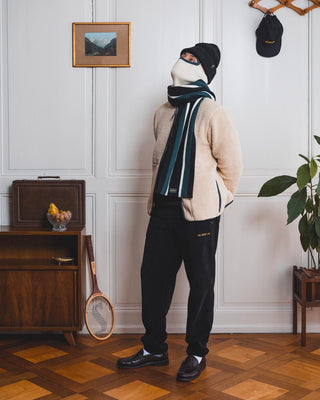 Man sitting in front of a vintage background wearing a Val Mont Lac outfit