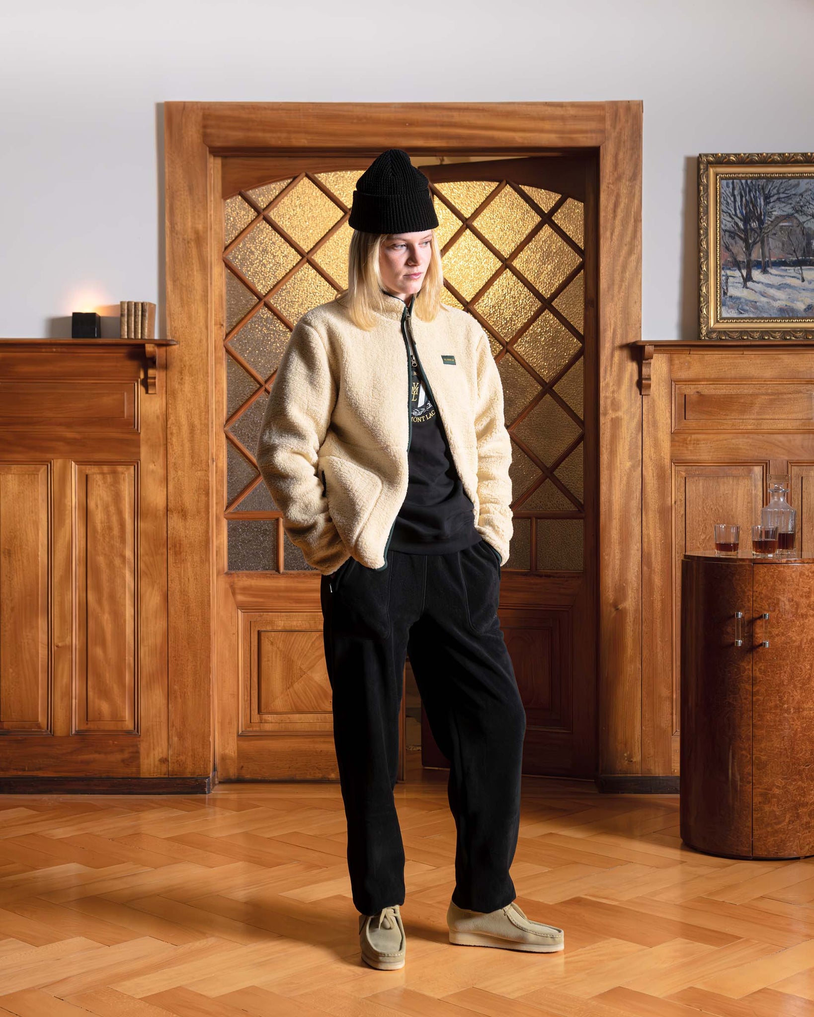 Woman wearing a Val Mont Lac fleece jacket and black outfit standing in a Swiss chalet