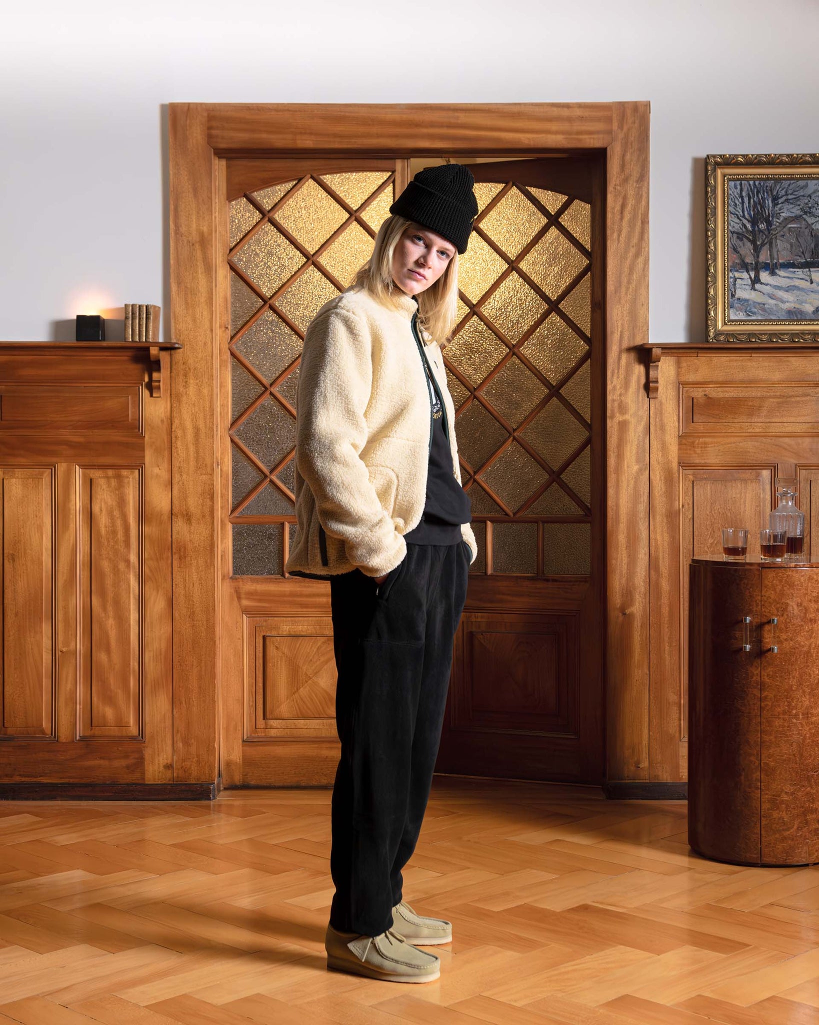 Woman wearing a Val Mont Lac fleece jacket and black outfit standing in a Swiss chalet