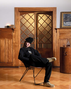 Woman wearing a Val Mont Lac clothing outfit sitting on a vintage designer chair in a Swiss chalet