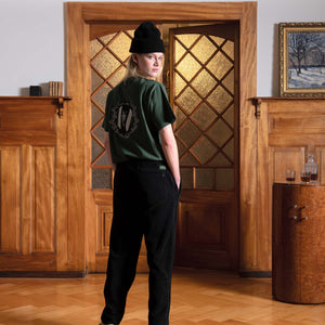 Blond woman from the back standing in a vintage Swiss chalet, wearing a Val Mont Lac Winter outfit